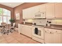 Bright kitchen with white cabinets, tiled floor, and an adjacent breakfast nook area at 1442 Carlow Cir, Ormond Beach, FL 32174
