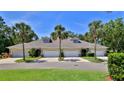 Charming townhome featuring a well-manicured lawn, palm trees, and a two-car garage at 1999 Turnbull Lakes Dr, New Smyrna Beach, FL 32168