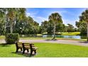 Beautiful community featuring a tranquil pond view, lush landscaping, and shaded bench at 1999 Turnbull Lakes Dr, New Smyrna Beach, FL 32168