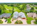 Stunning aerial view of a home on a golf course with a pool and circular driveway at 2005 Country Club Dr, Port Orange, FL 32128