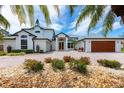 Stunning two-story home with a paver driveway, complemented by colorful flowers and lush tropical landscaping at 2005 Country Club Dr, Port Orange, FL 32128