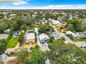 Aerial view showcases the community with mature trees, nearby rooftops, and streetscape at 216 Murray St, New Smyrna Beach, FL 32168