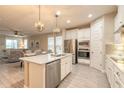 Bright kitchen with stainless steel appliances, a large island with quartz countertop, and hardwood floors at 219 Venetian Palms Blvd, New Smyrna Beach, FL 32168