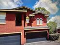 Red stucco townhouse with attached two-car garage at 240 Villa Di Este Ter # 212, Lake Mary, FL 32746