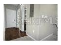 Hallway with dark wood floors and white walls leads to other rooms of the house at 240 Villa Di Este Ter # 212, Lake Mary, FL 32746