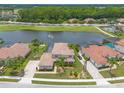 Beautiful aerial view of home with lake view, screened in pool and well-manicured lawns at 254 Cappella Ct, New Smyrna Beach, FL 32168