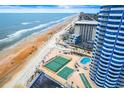 Scenic aerial view showcasing the condo's pool, tennis courts, beachfront access, and proximity to the ocean at 2625 S Atlantic Ave # 18Nw, Daytona Beach, FL 32118