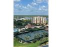 Scenic view of tennis courts, swimming pool, and lush landscaping with the ocean in the background at 265 Minorca Beach Way at 265 Minorca Beach Way # 902, New Smyrna Beach, FL 32169