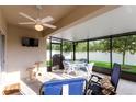Enclosed patio featuring a dining set, lounge chairs, and fan with peaceful outdoor view at 2818 Taton Trce, New Smyrna Beach, FL 32168