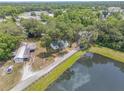 Aerial view of property with mature trees, a large pond and outbuildings at 2917 Crockett Pt, Sanford, FL 32773