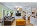 Cozy living room features comfortable leather seating, built-in shelving, and lots of natural light at 3048 Mango Tree Dr, Edgewater, FL 32141