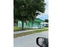 Side view of a charming, vintage green home with a picket-fenced porch and mature landscaping at 306 Sheldon St, New Smyrna Beach, FL 32168