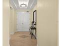Bright hallway with decorative table, mirror and double-door closet at 3245 S Atlantic Ave # 208, Daytona Beach, FL 32118