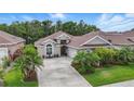 Inviting single-story home with a well-manicured lawn, mature landscaping, and a concrete driveway at 3378 Leonardo Ln, New Smyrna Beach, FL 32168