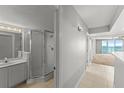 Bathroom featuring a vanity with a mirror, bright lights, and a walk-in shower with glass door at 3425 S Atlantic Ave # 902, Daytona Beach, FL 32118