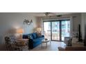 Cozy living room with tile floors, ceiling fan, furniture and access to the balcony at 4175 S Atlantic Ave # 2280, New Smyrna Beach, FL 32169