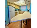 Functional kitchen featuring bright cabinetry, ample counter space, and breakfast bar at 421 S Atlantic Ave # 407, New Smyrna Beach, FL 32169