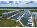 Aerial view of a marina with boat docks and waterfront condo buildings at 4620 Riverwalk Village Ct # 7306, Ponce Inlet, FL 32127