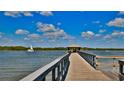 Scenic wooden pier with a covered gazebo overlooking the water and a sailboat at 4620 Riverwalk Village Ct # 7306, Ponce Inlet, FL 32127
