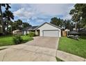 Charming single-story home with a two-car garage, long paver driveway, and well-maintained landscaping at 475 Spruceview Dr, Port Orange, FL 32127