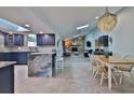 Bright open-concept kitchen and dining area flowing into the living room with stone fireplace, and skylights at 475 Spruceview Dr, Port Orange, FL 32127