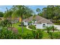 Inviting one-story home with a well-manicured lawn and tropical landscaping around the house at 484 Sweet Bay Ave, New Smyrna Beach, FL 32168