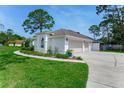 Charming one-story home featuring a three-car garage, well-manicured lawn and fresh landscaping at 484 Sweet Bay Ave, New Smyrna Beach, FL 32168