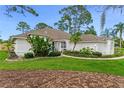 Charming single-story home featuring a lush green lawn, tropical landscaping and a bright blue front door at 484 Sweet Bay Ave, New Smyrna Beach, FL 32168