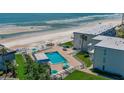 Aerial view of condo complex with beach access, pool, and well-kept green spaces at 4849 Saxon # C202, New Smyrna Beach, FL 32169