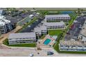 Aerial view of condo complex featuring parking, tennis courts, a pool, and direct beach access at 4849 Saxon # C202, New Smyrna Beach, FL 32169
