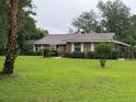 Well-maintained brick home featuring manicured landscaping and a lush green lawn at 547 Cleo Ln, Deltona, FL 32738