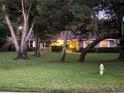 Exterior view of a brick home with mature trees in the front yard at twilight at 547 Cleo Ln, Deltona, FL 32738