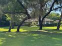 Beautiful single-story brick home with mature trees and a sprawling green lawn on a sunny day at 547 Cleo Ln, Deltona, FL 32738