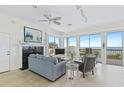 Bright living room with large windows overlooking the ocean, fireplace, and comfortable seating at 6320 S Atlantic Ave, New Smyrna Beach, FL 32169