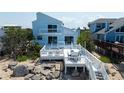 Expansive white deck with seating and dining areas, perfect for outdoor relaxation with ocean views at 6871 S Atlantic Ave., New Smyrna Beach, FL 32169