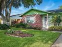Beautifully landscaped home with a lush green lawn, colorful flowers, and a charming front entryway at 708 Egret Ct, Edgewater, FL 32141