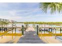 Scenic view of calm waterway with dock, adjacent to community condominium buildings at 76 Heather Point Ct, New Smyrna Beach, FL 32169