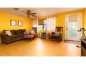 Bright living room with hardwood floors, ceiling fan, sofa, and rocking chair at 804 E 12Th Ave, New Smyrna Beach, FL 32169