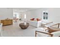 Bright, open living area featuring modern decor, white floors, and a neutral color scheme complemented by a dining area at 833 E 12Th Ave, New Smyrna Beach, FL 32169