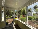 A cozy screened porch provides a tranquil view of the lush surroundings and a glimpse of the driveway at 125 Rio Vista Dr, Edgewater, FL 32132
