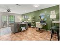 Bright living room featuring a green accent wall, a comfortable sofa and a desk, complemented by tiled flooring at 140 Limewood Pl # C, Ormond Beach, FL 32174