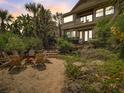Charming backyard with a fire pit and Adirondack chairs, set against a backdrop of native landscaping at 1421 N Atlantic Ave, New Smyrna Beach, FL 32169