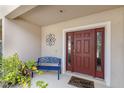Warm and inviting front entryway with decorative floral metal art, bench, and a 'Home Sweet Home' welcome mat at 1615 Primo Ct, Holly Hill, FL 32117