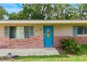 Inviting front entrance with a bright blue door and brick exterior at 1723 Needle Palm Dr, Edgewater, FL 32132