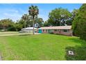 Spacious front yard with mature trees surrounding a cozy home at 1723 Needle Palm Dr, Edgewater, FL 32132