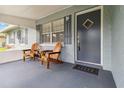 Inviting front porch featuring wood chairs and a small table, perfect for enjoying the outdoors at 1920 Travelers Palm Dr, Edgewater, FL 32141