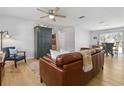 Bright living room with ceiling fan, laminate flooring, and comfortable leather seating at 1920 Travelers Palm Dr, Edgewater, FL 32141