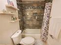 Cozy bathroom featuring a tub with tile surround, floating shelves, and decorative shower curtain at 1941 Spruce Creek Lndg, Port Orange, FL 32128