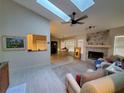 Bright living room with skylights, fireplace, ceiling fan, and open dining area at 1941 Spruce Creek Lndg, Port Orange, FL 32128