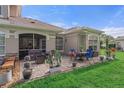 Rear patio with an outdoor seating area, a BBQ, and lush green grass at 1983 Turnbull Lakes Dr, New Smyrna Beach, FL 32168